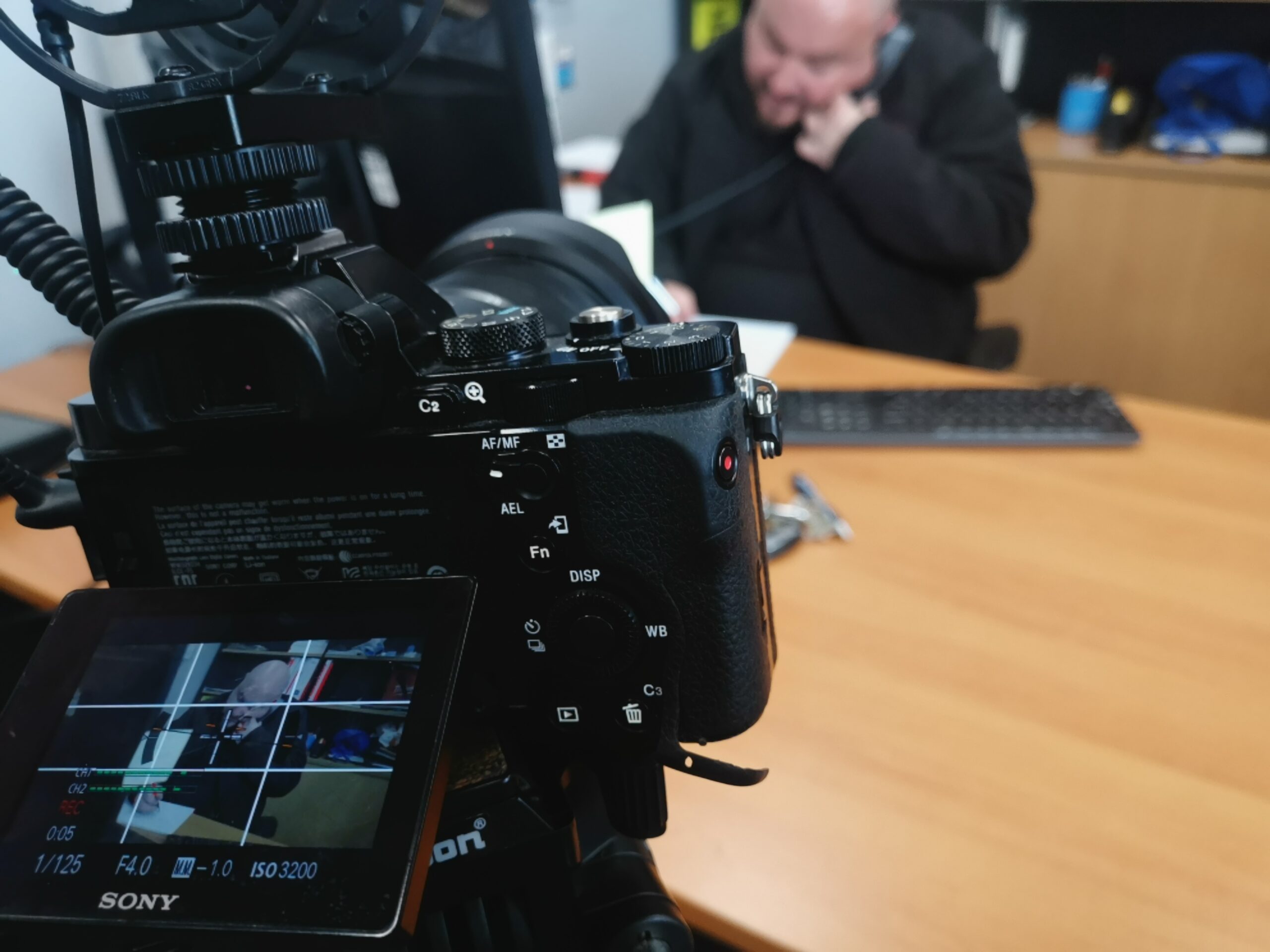 Close up of the DSLR screen showing Steve in the background
