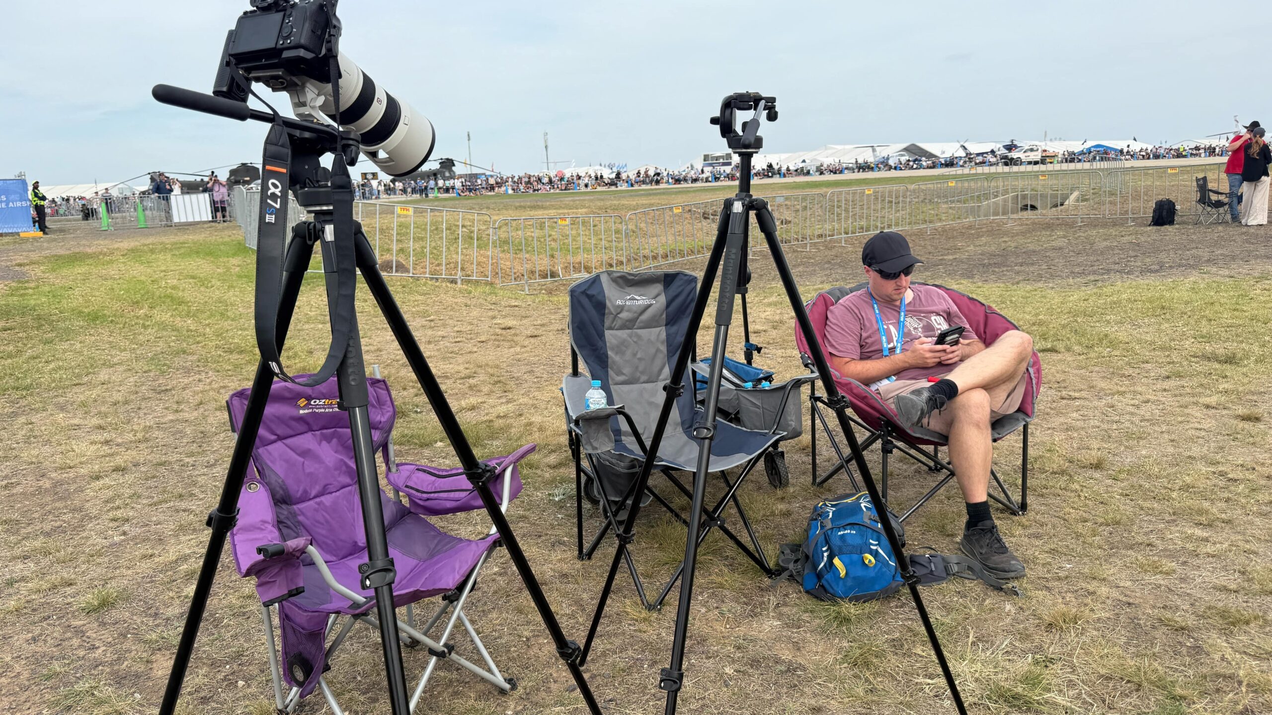 Me sitting on a chair at the air show near my camera equipment 
