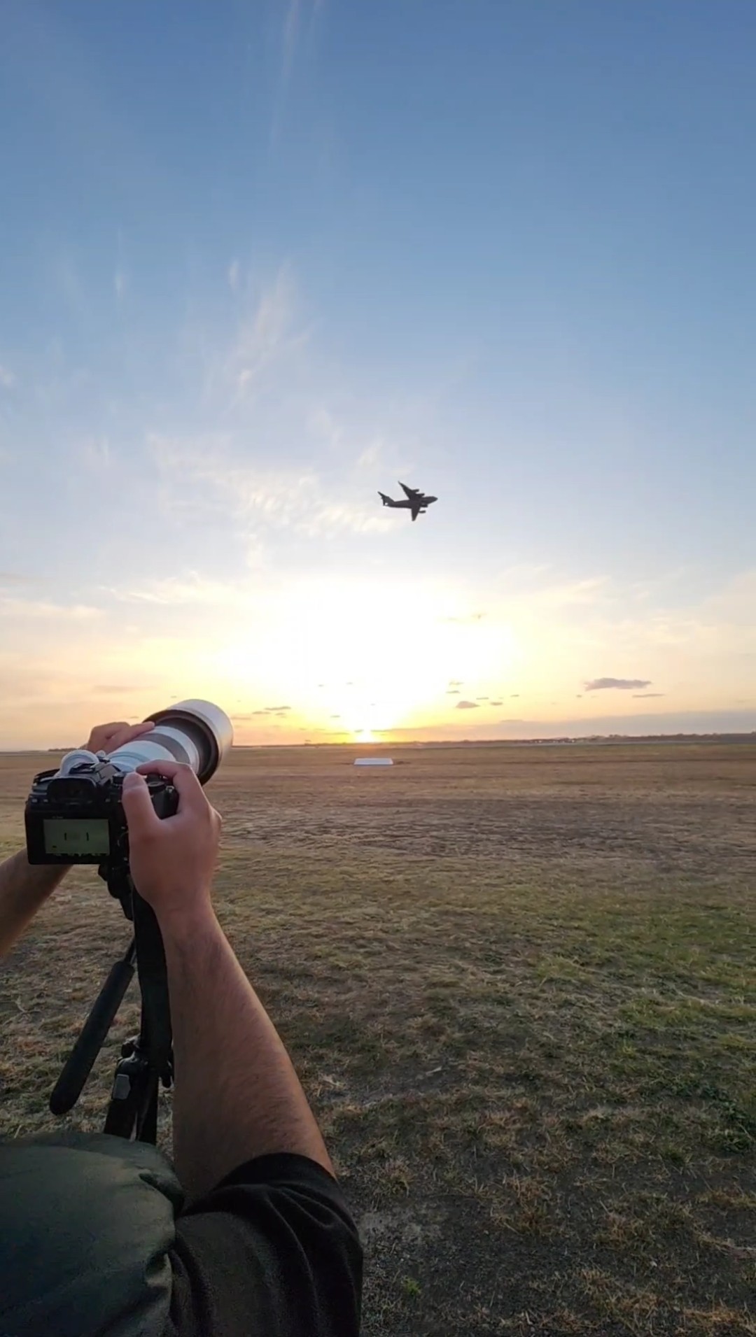A military aircraft flying over the golden hour sunset
